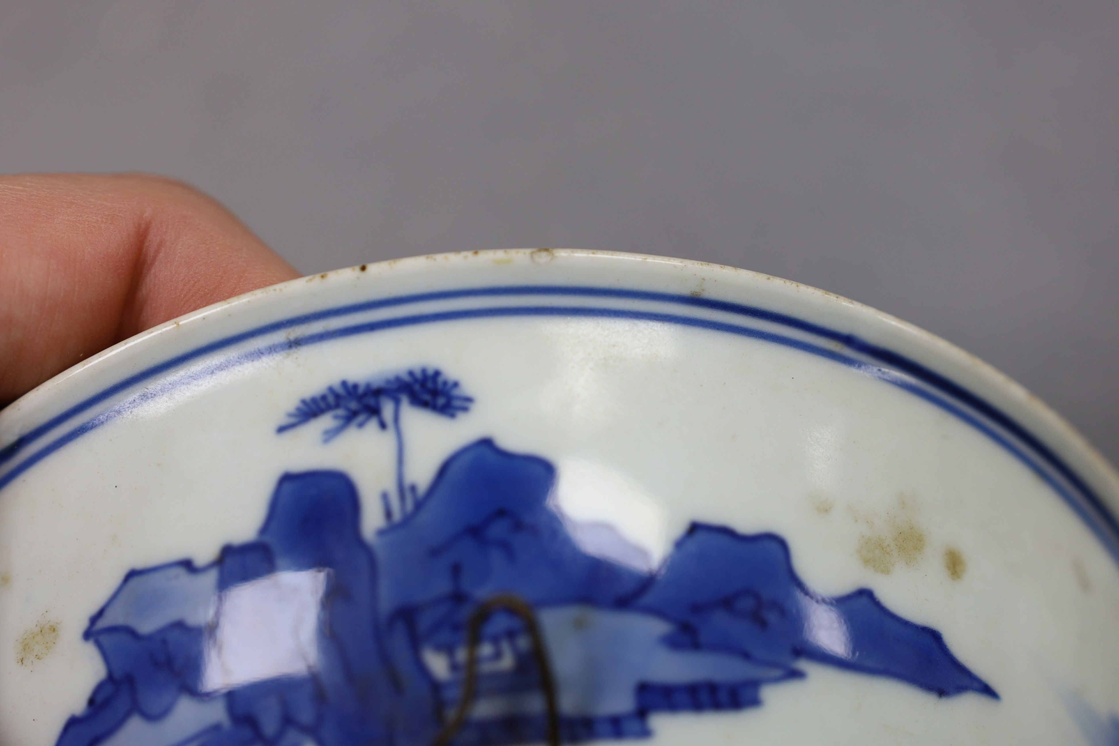 NB BOTH WITH HAIRLINE CRACKS A pair of Chinese blue and white small dishes, Kangxi six character marks and of the period (1662-1722), 15.7cm and 15.8cm diameter, foot later pierced, hairline cracks